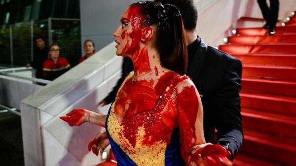 Cannes 2023. Apariţie şocantă pe covorul roşu, o femeie a venit îmbrăcată în culorile Ucrainei şi acoperită de sânge fals, în semn de protest