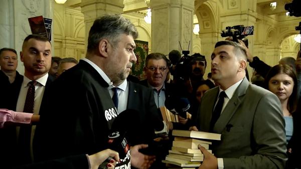 Circ la Parlament. George Simion i-a dat premierului o carte Harry Potter şi a refuzat să dea mâna cu el: Am auzit că şi-a luat BAC-ul mai târziu