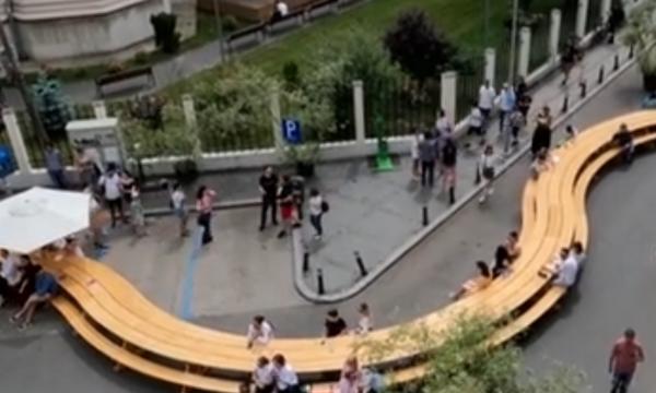 O masă uriaşă, şerpuitoare, tronează într-o piaţetă din centrul Capitalei. Oamenii şi-au dat întâlnire şi stau la taifas, în intersecţie