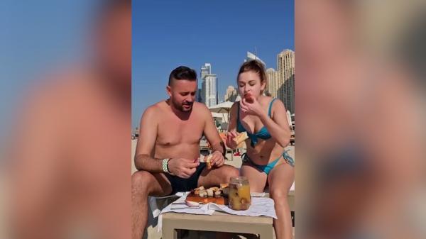 Doi români au mâncat slănină cu ceapă pe o plajă din Dubai: "Dacă ne prind ăştia, ne bagă în puşcărie. Noi mâncăm şi în spatele nostru e Burj al-Arab"