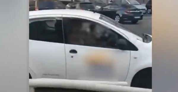 Inconştienţă la volan. Şofer, filmat în timp ce conduce cu un copil în braţe, pe un bulevard aglomerat