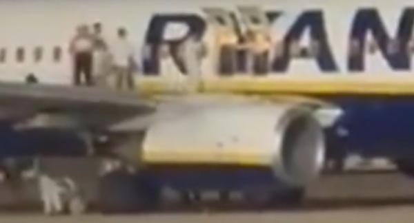 Momentul în care pasagerii sar de pe aripa unui avion pe asfalt după declanşarea unei alarme false de incendiu