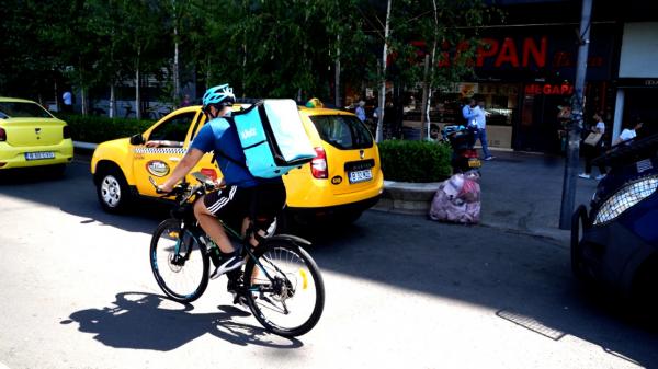 "Suntem aici să facem bani, trebuie să muncim". Livratorii înfruntă canicula şi lucrează 11 ore pe zi