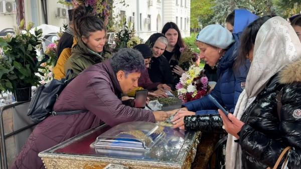 O femeie a "sărutat" moaştele Sf. Parascheva şi s-a rugat prin video call, ajutată de o pelerină