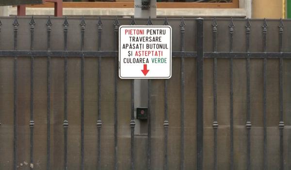 Situaţie ridicolă în Braşov. Pietonii care vor să traverseze apasă butonul semaforului printr-o gaură în gard