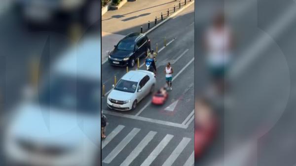 Fetiţă într-o maşină electrică, filmată pe şosea pe Calea Victoriei. Tatăl o ghida, printre maşini