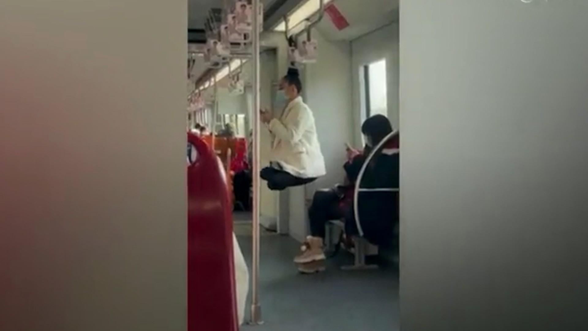 Rusoaică filmată "levitând" la metroul din Shanghai. A stat agăţată cu părul de o bară, lăsându-i mască pe pasageri