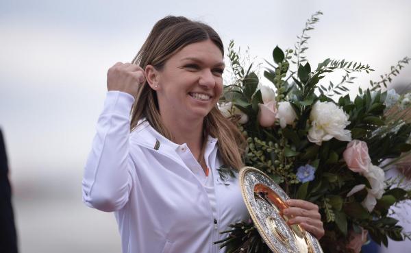 Simona Halep cu trofeul de la Wimbledon la sosirea în România