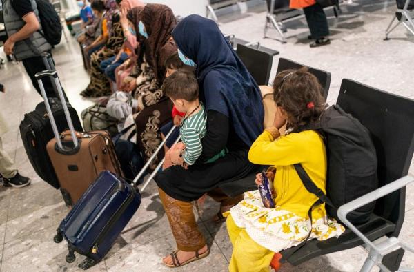 Refugiații afgani așteaptă să fie procesați după sosirea pe un zbor de evacuare din Afganistan, pe aeroportul Heathrow, Londra
