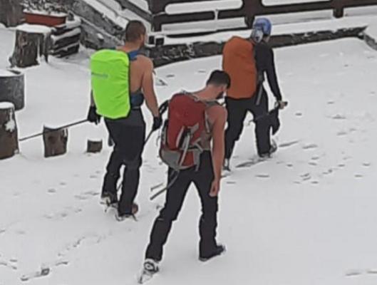 Turiști în maiouri, fotografiați de salvamontiști când plecau pe un traseu spre Parângul Mic, unde ninge și viscolește