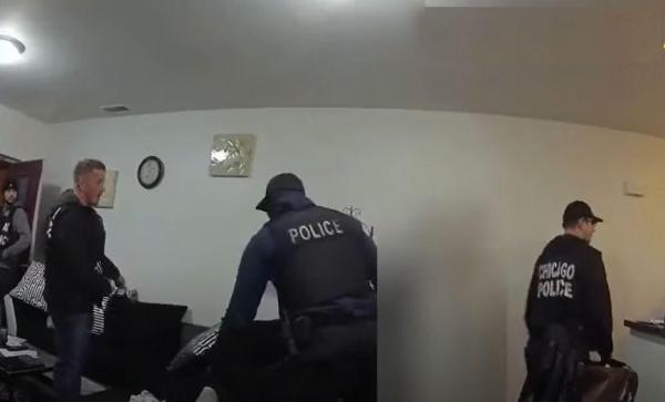 Polițiștii fac percheziții în apartamentul femeii, în timp ce aceasta stă lipită pe un perete