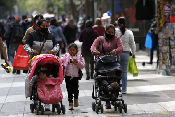 Mai multe mame purtând măști de protecție își plimbă copiii în centrul orașului Santiago, Chile