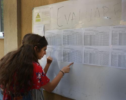 Eleva de clasa a VIII-a își cauta numele pe listele de rezultate obtinute la examenul de Evaluare Nationala