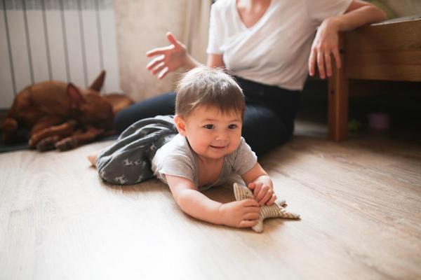 Un copil se joacă pe podea
