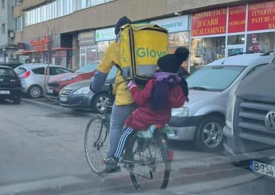 Un tată îşi duce copilul la şcoală în timp ce livrează mâncare în Bucureşti: "Primul gând a fost că Glovo livrează copii"