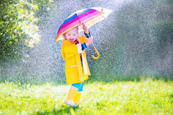 copil cu o umbrelă în ploaie