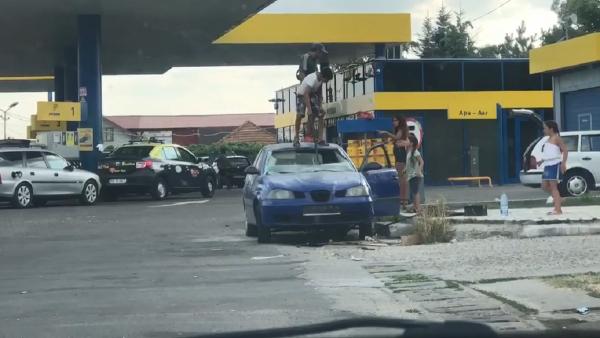 Maşină distrusă cu toporul în benzinărie, la Piteşti. Un copil loveşte şi el (video)