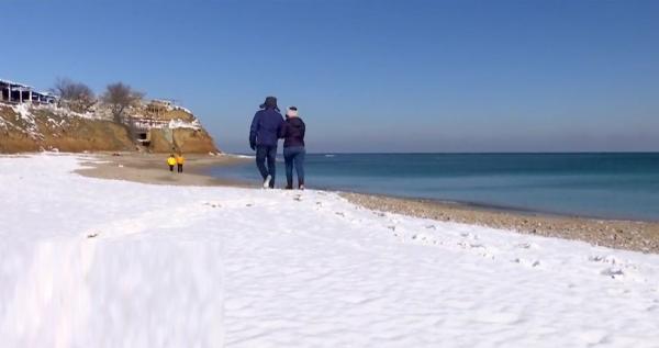 Soare şi ger la malul mării. Mulți turiști au înfruntat frigul de dragul unei plimbări pe nisipul acoperit de zăpadă