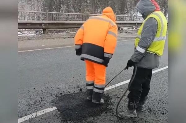"Asfaltare cu picioarele" în România. Imagini incredibile: un muncitor bate asfaltul abia turnat peste o groapă cu picioarele