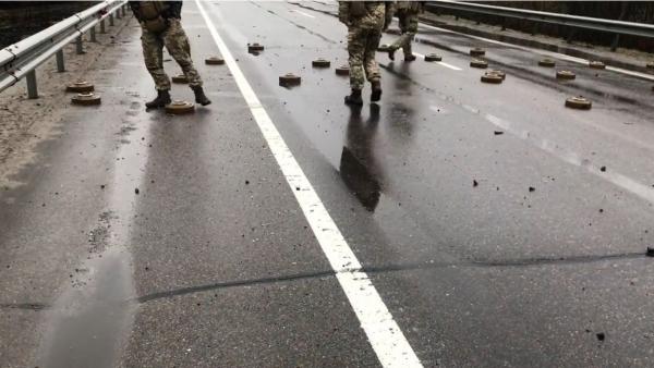 Minele antitanc lăsate de ruşi pe o şosea de lângă Kiev, mutate cu piciorul de soldaţii ucraineni