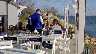 La malul mării, soarele este generos cu localnicii şi turiştii. Unii s-au aşezat la masă în restaurantele cu specific pescăresc, alţii se plimbă în tricou pe faleză