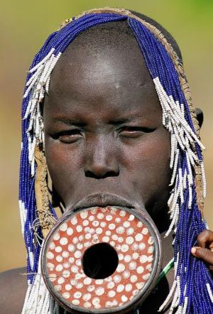 Imagini incredibile! Femeile dintr-un trib etiopian își pun FARFURII în buze!