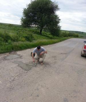 GALERIE FOTO: Sătul de incompetenţa autorităţilor, un tânăr repară singur găurile de pe şosele