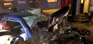 Imagini îngrozitoare! Două maşini s-au izbit în Bistriţa, la Feldru, una dintre ele a fost aruncată în faţa trenului. Trei oameni au rămas încarceraţi (video)