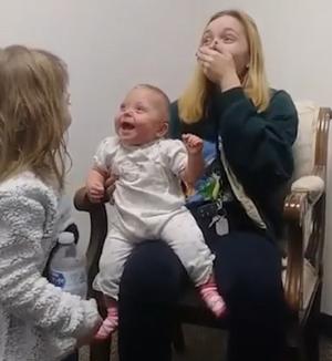 Bebelus în hohote de râs, după ce și-a auzit pentru prima oară surioara