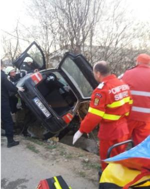 Imagini cumplite la Tetoiu, unde un copil de 4 ani şi un adolescent au murit în maşina strivită de un cap de pod