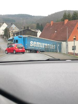 Şofer român nervos că nu are loc să vireze la stânga, dă cu spatele şi cade cu TIR-ul de pe şosea, în Germania