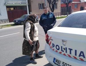 Bătrână urcată în maşina de poliţie, la Năsăud. Femeia se grăbea să nu depășească intervalul orar permis vârstnicilor