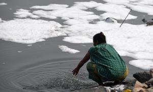 Un râu sacru din India a fost acoperit de spumă toxică. Localnicii îşi riscă sănătatea şi se scaldă pentru a respecta ritualurile