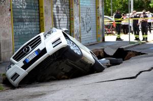 Două mașini au fost înghițite de o groapă apărută în asfalt, adâncă de șase metri, la Roma - VIDEO