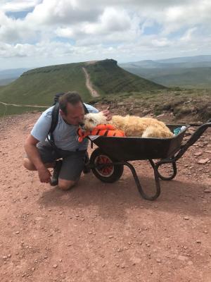 Un britanic şi-a dus câinele aflat pe moarte pe muntele său preferat, într-o roabă, pentru o ultimă plimbare: ''Dumnezeu să te binecuvânteze''