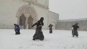 "Dragi frați și surori, a sosit sora zăpadă". Călugări surprinși jucându-se cu bulgări și distrându-se în fața Bazilicii Sfântul Francisc din Assisi, în Italia