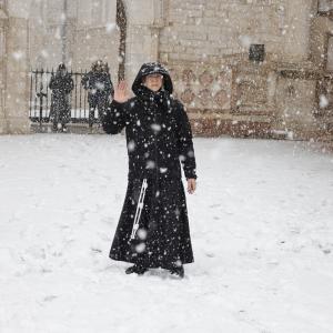 "Dragi frați și surori, a sosit sora zăpadă". Călugări surprinși jucându-se cu bulgări și distrându-se în fața Bazilicii Sfântul Francisc din Assisi, în Italia