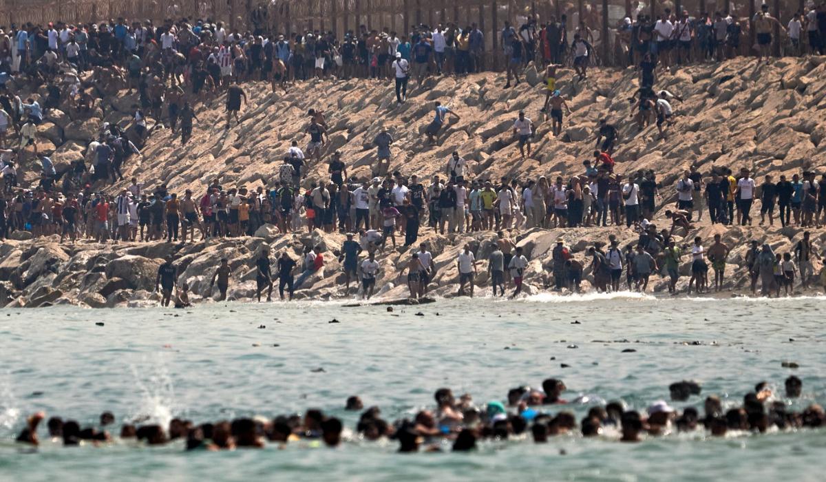 Migranți marocani ajung la granița spaniolă prin înot și forțează gardurile de frontieră.