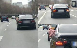 Copil filmat atârnând pe geamul deschis al unui BMW, în traficul din Bucureşti. Poliţiştii îl caută pe şofer